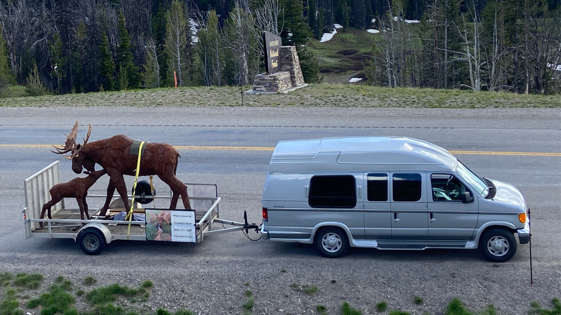 Artist Carl driving with Bull and calf moose sculpture on a trailer during a faith journey